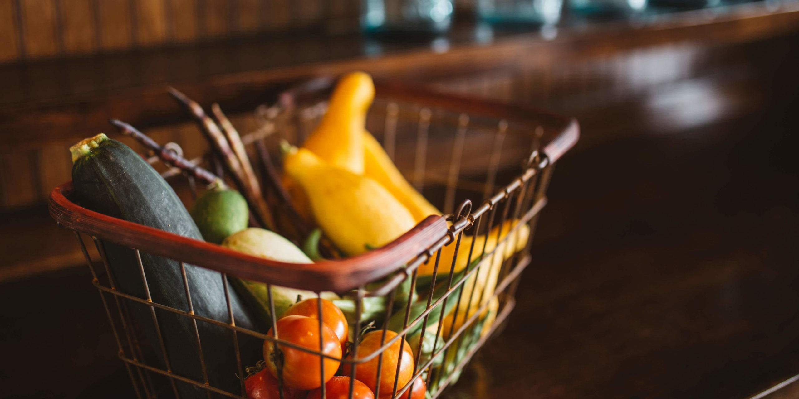 Vegetables in a hand basket sitting on a counter Vegetables in a hand basket sitting on a counter